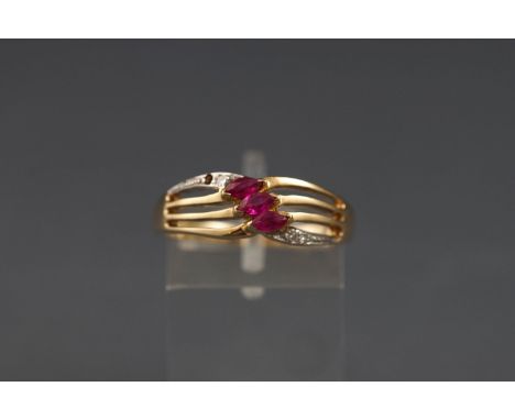 A 9ct gold, ruby and diamond dress ring, the open pierced cross-over head centred with three marquise rubies with small eight