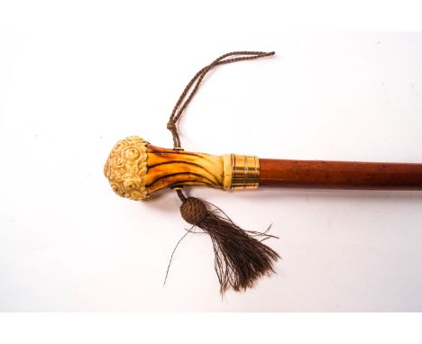 A Malacca walking stick, the knop being a faux ivory bunch of flowers, together with a putti also holding flowers