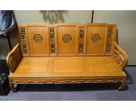 A Chinese hardwood three seat sofa with carved pierced back and solid seat, 172cm long