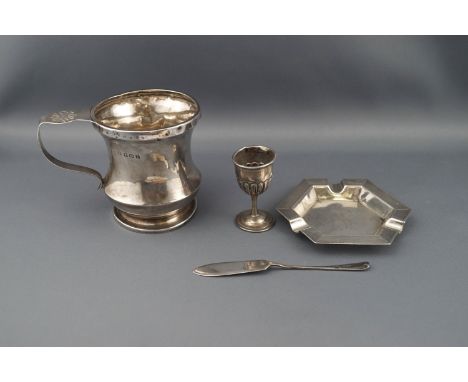 Four items of silver; comprising a 'waisted' christening mug on foot with a florette pierced scroll handle, Birmingham 1929 b