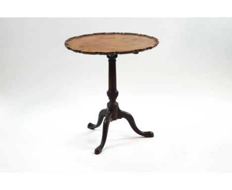 A George III mahogany tripod table, the tilt top with pie crust edge on turned column and pad feet, 69cm high x 64cm diameter