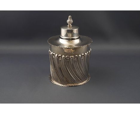 A late Victorian silver cylindrical tea caddy, part spiral fluted with flared and crimped borders and a pull-off cover with f