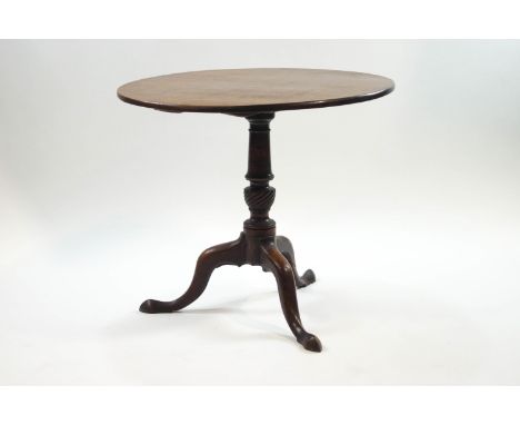 A George III style mahogany tripod table, the tilt top upon a turned column and pad feet, 72cm high x 83cm diameter