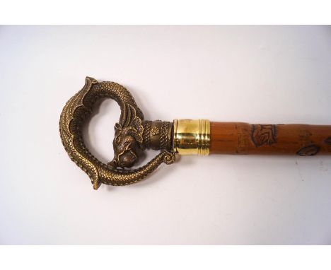 A Japanese walking stick, the shaft carved with a snake chasing a frog, the handle being a dragon with the pearl of wisdom in