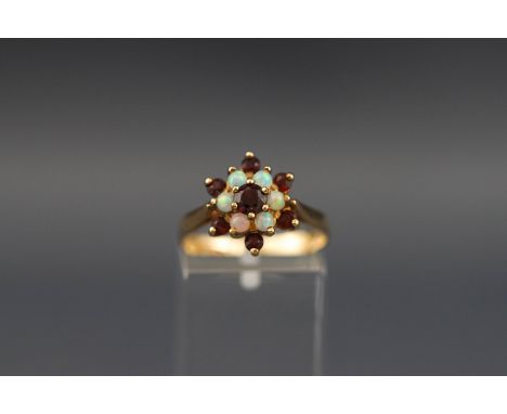 A 9ct gold, garnet and white opal cluster ring, post 2000 London convention marks, size O, 2.5 grams gross.