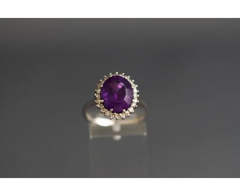 An 18ct white gold, amethyst and diamond oval cluster ring, centered with an oval mixed-cut amethyst within an eight-cut diam