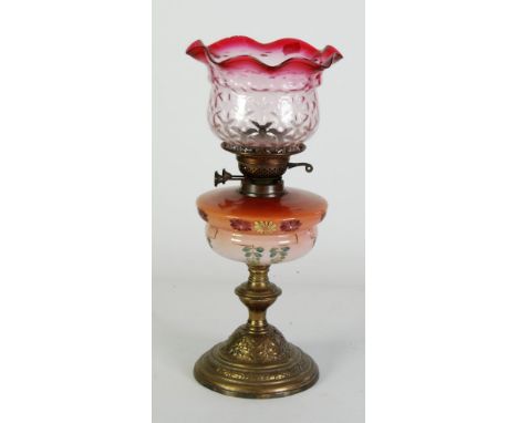 VICTORIAN TABLE OIL LAMP with floral painted and shaded pink glass receiver to embossed brass base with knop stem and stepped