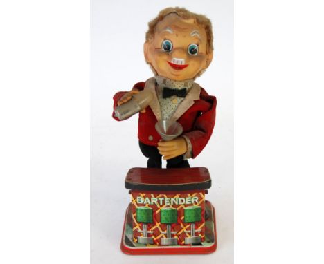 TN, JAPAN, BATTERY POWERED TINPLATE AND FABRIC BARTENDER TOY AUTOMATON, depicted dispensing cocktails, 13 3/4" high 