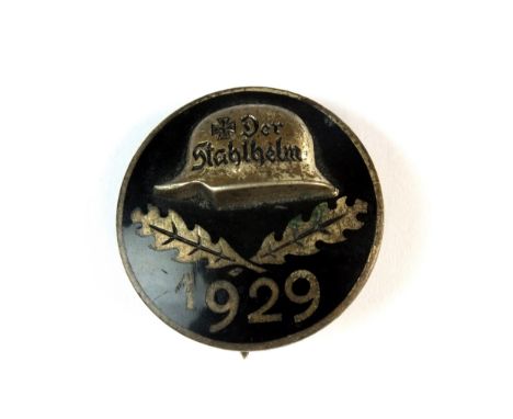 A Weimar German 1929 Der Stahlelm sevice badge of entry, of circular form with black enamel, with steel helmet in relief abov