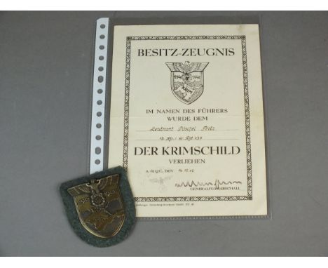 A German Second World War Army armshield, in bronzed zinc with an eagle and swastika on a shield bearing the dates 1941/42 to