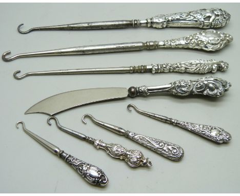 Silver handled button hooks and a paper knife 