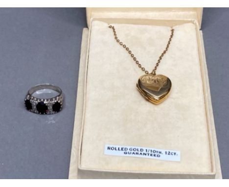 Silver and garnet three stone ring size M 4.2g gross, and a rolled gold heart shaped locket and chain