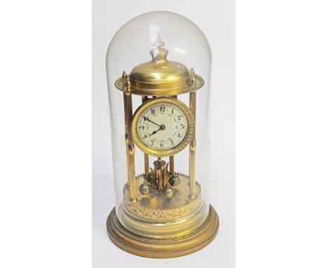 A brass revolving pendulum mantel clock under glass dome. H43cm.