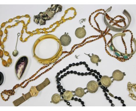 A quantity of costume jewellery including a jet mourning brooch, a shell snuff box, beads etc.