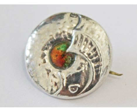 A Liberty & Co Cymric silver brooch formed as a mythical dolphin with enamel centre, diam. 2cm.