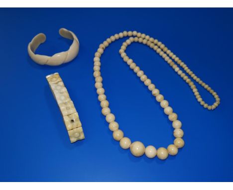 A string of antique ivory graduated beads, 28"; a plaque bracelet; a bangle 