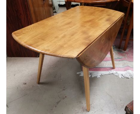 An Ercol light elm drop leaf dining table on square tapering legs 