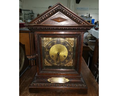 A late Victorian mantel clock in oak architectural case, brass dial 