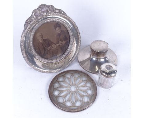 A silver Capstan inkwell, an embossed silver circular photo frame, a silver-topped hair tidy, and a glass and silver-mounted 