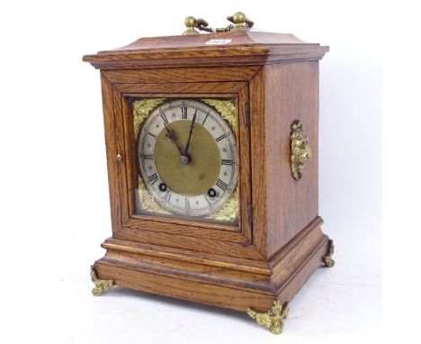 A German oak-cased 8-day bracket clock, brass dial with Roman numeral hour markers and brass lion mounts, movement striking o