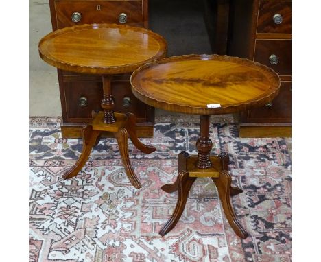 A pair of oval mahogany lamp tables, on reeded sabre leg base 