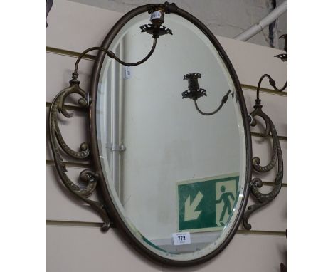 A 19th century brass-framed oval bevel-edge wall mirror, with swivel candlestick fittings, overall height 50cm 