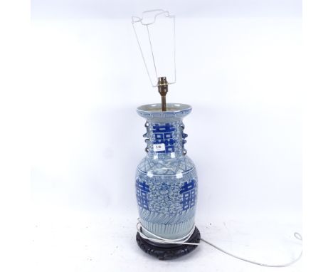 An Oriental blue and white porcelain lamp on carved wood base, height overall 70cm 