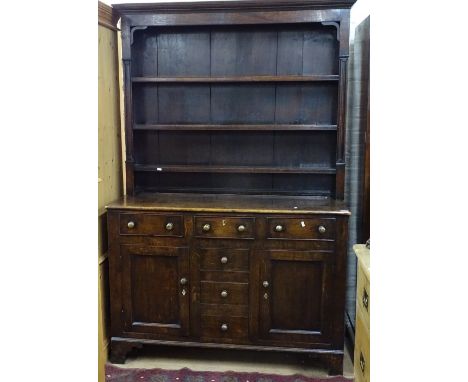 An Antique oak 2-section dresser, having a boarded open plate rack above 3 frieze drawers, with dummy drawers and panelled cu