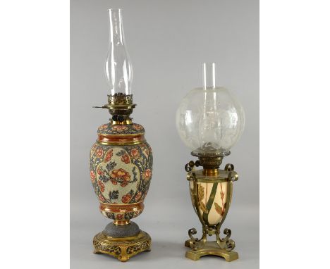 Brass oil lamp, the ceramic reservoir decorated with lilies and another decorated with flowers on a textured stoneware reserv