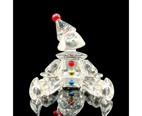 Figure with a clear faceted body and frosted face with blue eyes. Red pom-pom on the hat. Red, yellow, and blue buttons on th