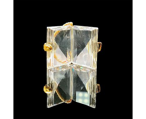 A clear open ledger with gold plated accents and a thread in the center. This item has its original box: 3.25"L x 2.25"W x 1.