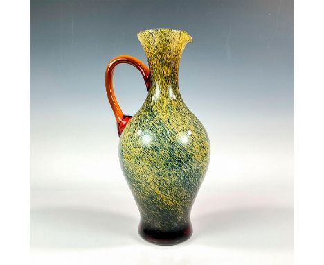 A large mid century pitcher with applied orange handle. The pitcher is case with an opaque interior and a blue splatter overl