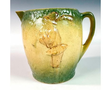 An early ware ceramic pitcher embossed with a boy carrying a mug and playing an instrument on each side. Dimensions: 8.5"W x 