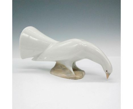 Glazed figural bird, facing down is colored in soft white on tan base. Nao imprint. Dimensions: 6"L x 2"W x 3"HManufacturer: 