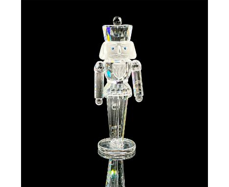 A clear faceted figure with a frosted face, blue eyes, and black crystal accents on the hat and belt. Swarovski mark. This it