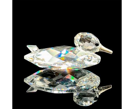 A clear faceted body with black eyes and a metal bill. Swarovski mark. This item has its original box: 2.5"W x 2.75"H. Artist