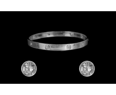 18ct White Gold Attractive Cartier Style Diamond Set Bangle, set with 10 brilliant cut diamonds of good colour and clarity.  