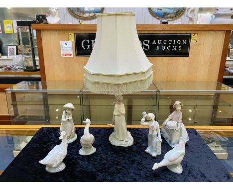 Collection of Nao by Lladro, comprising a lamp base of a young girl, measures 21'' including fringed shade, three Nao geese, 