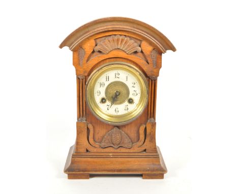 Junghans - An early 20th century mahogany eight day mantel clock. Carved front with pine cone moulded relief, white face with