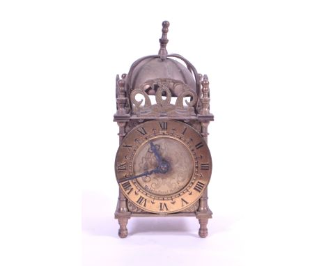 An early 20th century Smiths brass lantern clock. Raised on rounded bun feet, having Roman numeral dial. Marked Made in Great