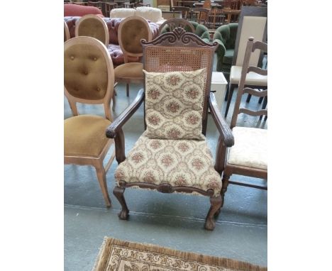 A George I style mahogany bergere open armchair, carved top rail over tapestry seat, raised on ball and claw feet