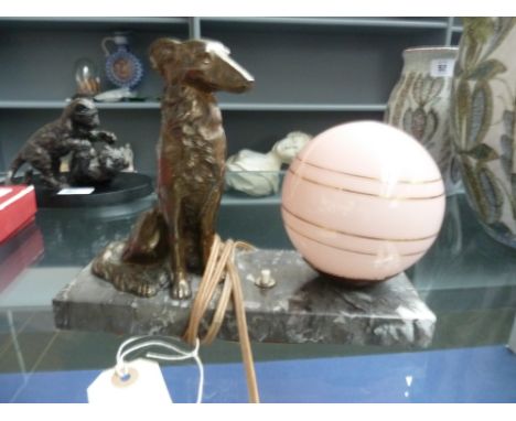 A French Art Deco spelter dog lamp, the Alsatian seated next to a pink coloured globe shade, 22cm wide 
 