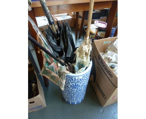 A ceramic umbrella stand in the Chinese taste, blue glaze, with umbrellas 