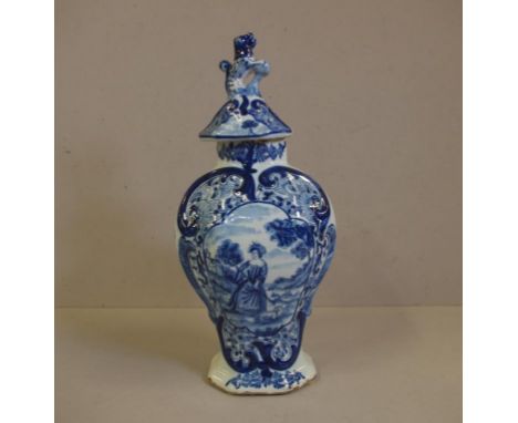 18th century Delft blue & white lidded urn painted Norman figure in cartouche, dog and Fu finial, rim chips and restoration, 