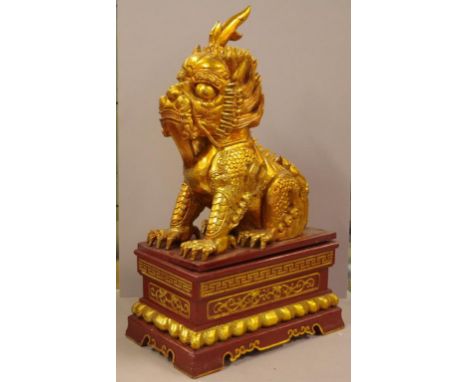 Large Chinese carved gilt temple lion statue on stand, H74cm approx