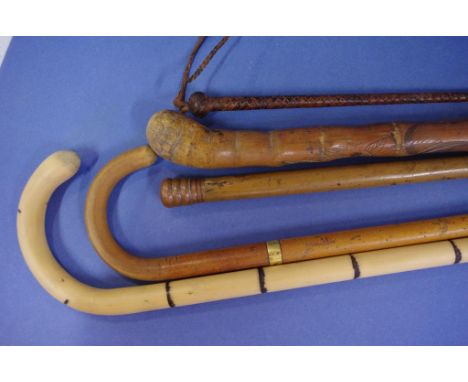 Four assorted walking sticks one a poachers fishing stick & another with a cigarette lighter under screw top, together with a