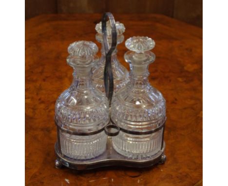 Three Georgian cut glass decanters one decanter chip to rim and stopper, 20cm high, with plated stand,