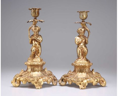 A PAIR OF 19TH CENTURY GILT-BRONZE CANDLESTICKS each stem in the form of a putto. (2) 25cm high