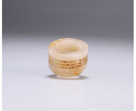 A CHINESE JADE THUMB RING circular with carved bands. 3.5cm diameter