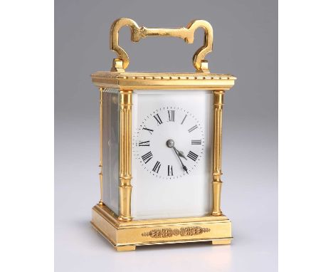A FRENCH BRASS CARRIAGE CLOCK, CIRCA 1900 with columnar corners and hinged carrying handle, white enamel dial with Roman nume